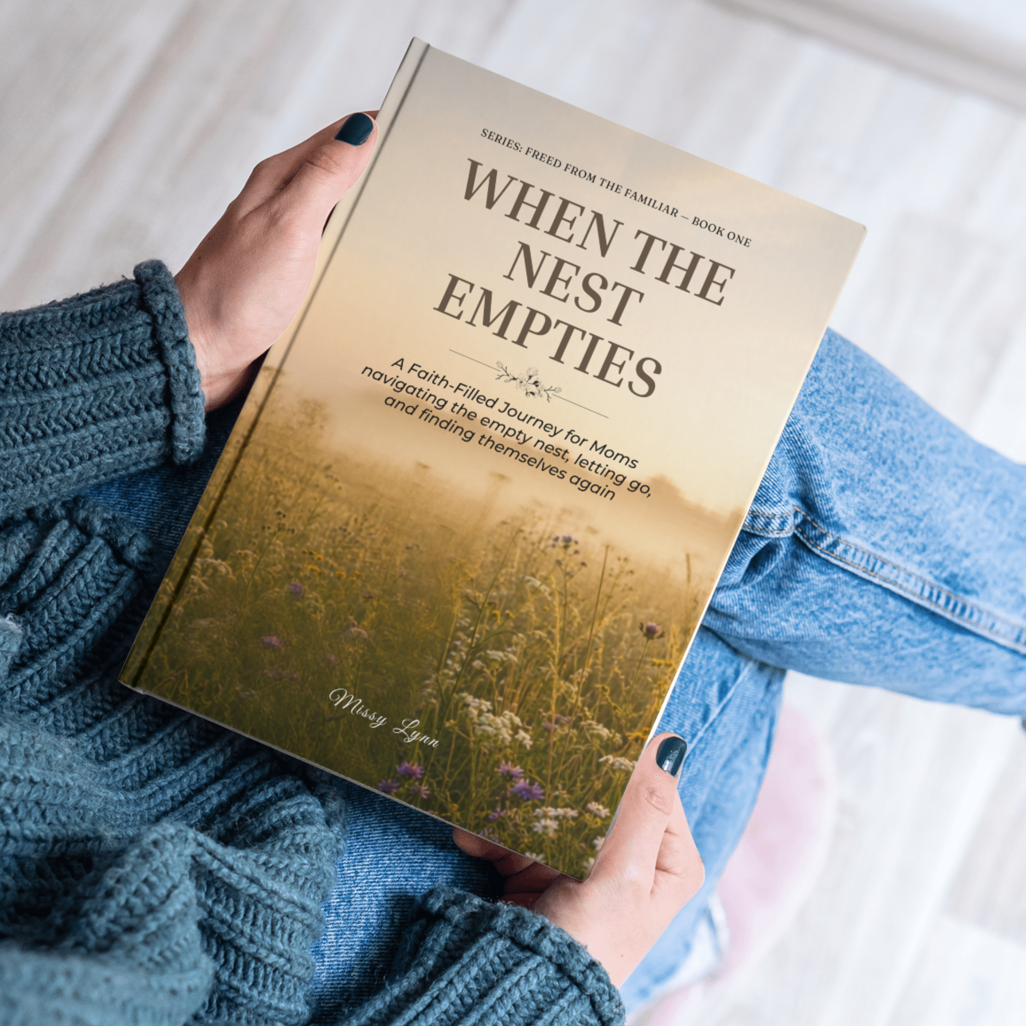 Woman in blue sweater holding book When the Nest Empties faith ebook for Christian moms held by woman in cozy blue sweater